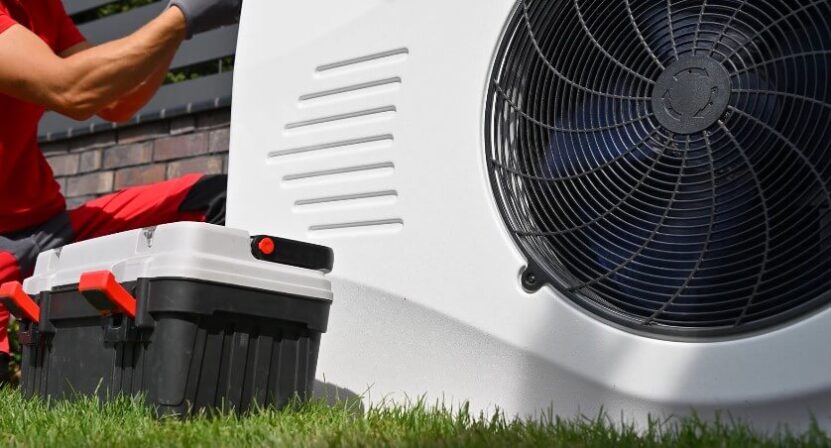 Man fixing outside HVAC unit on a house