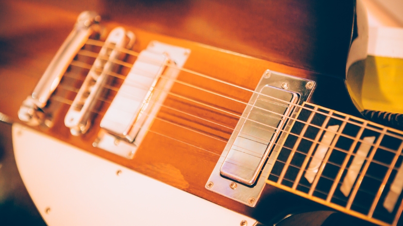 Close-up of an acoustic guitar with dual pickups mounted between the bridge and neck positions