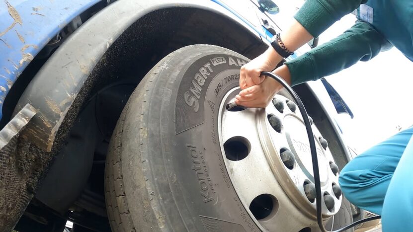 Checking truck tire pressure with a gauge